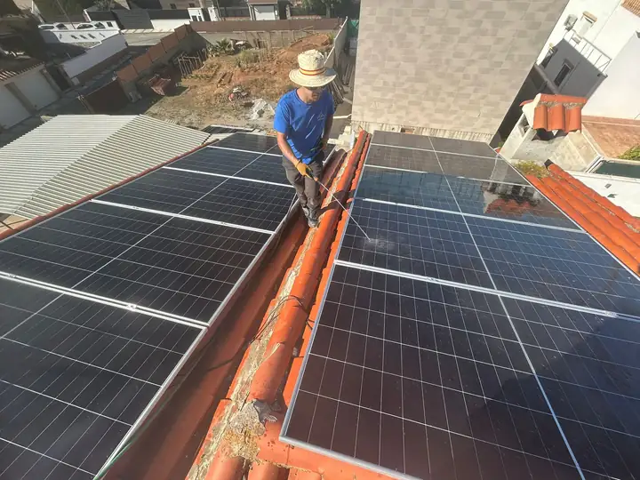 Técnico de JJ Instalaciones montando módulos fotovoltaicos sobre un tejado inclinado