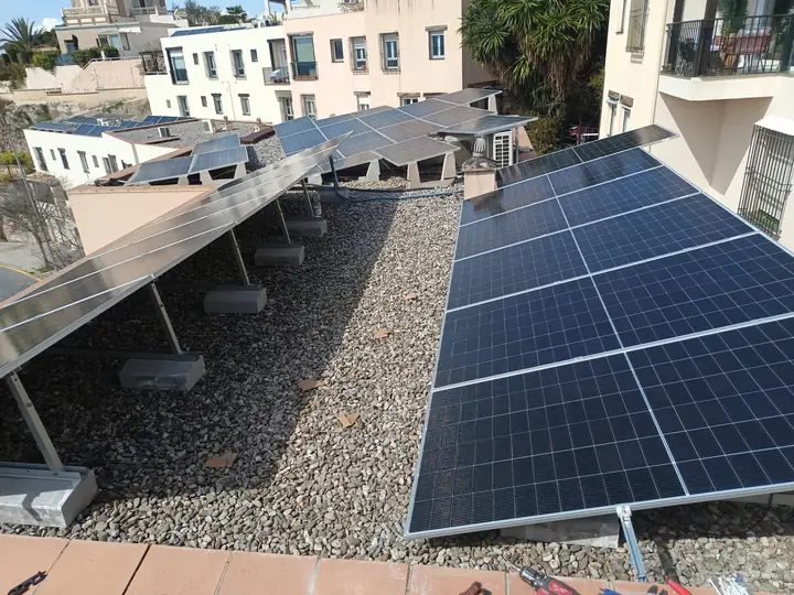 Módulos fotovoltaicos sobre estructura inclinada en la cubierta plana de un edificio