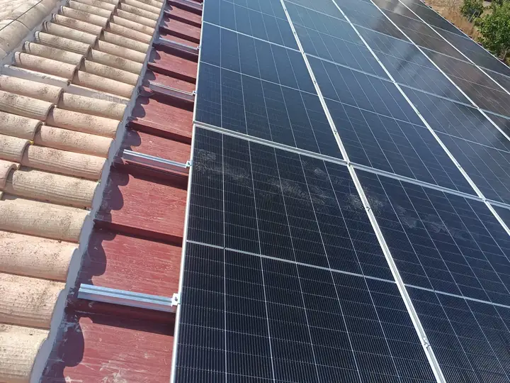 Hilera de placas solares instaladas sobre la cubierta de una nave agrícola